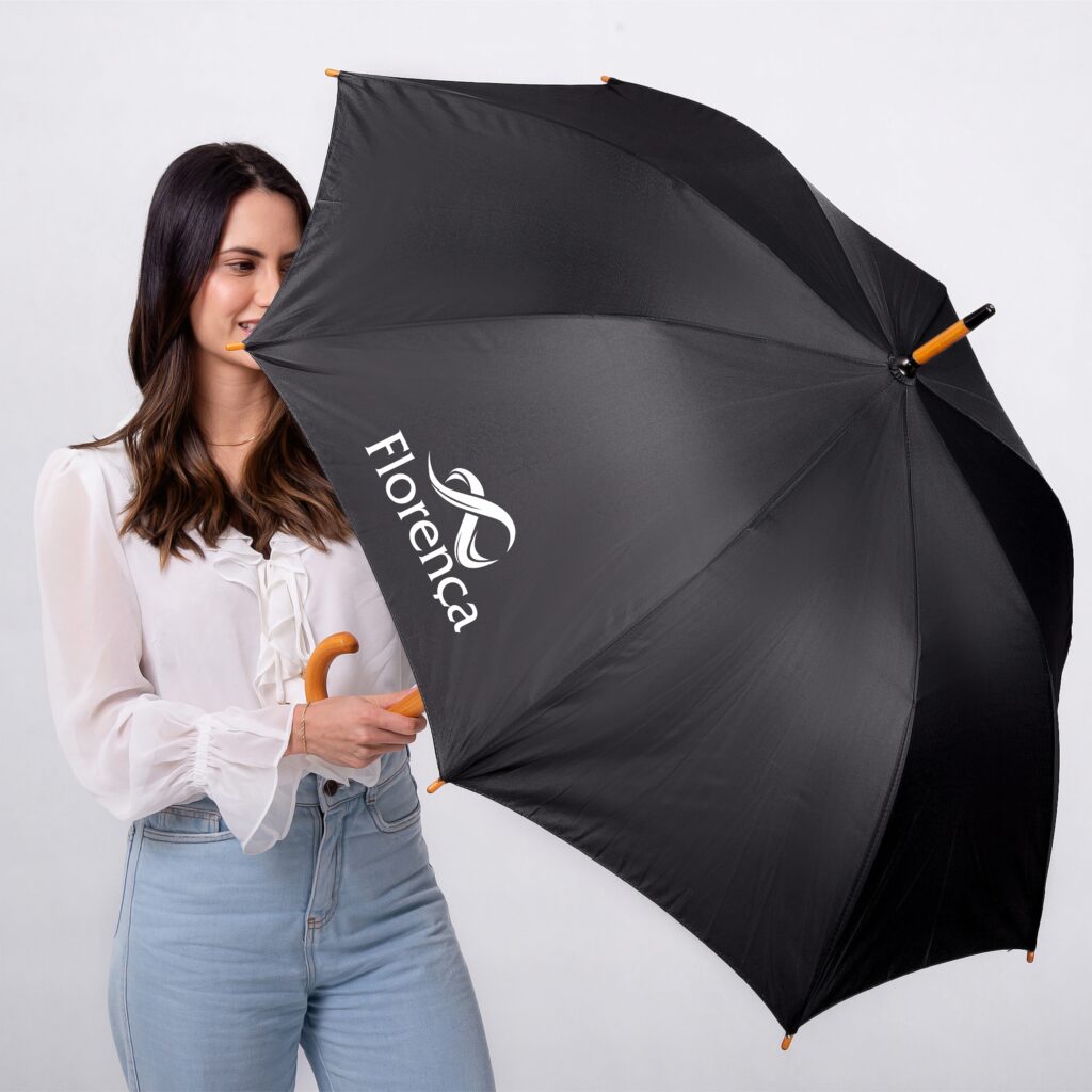 Mulher segurando guarda-chuva personalizado preto aberto com logomarca da Florença