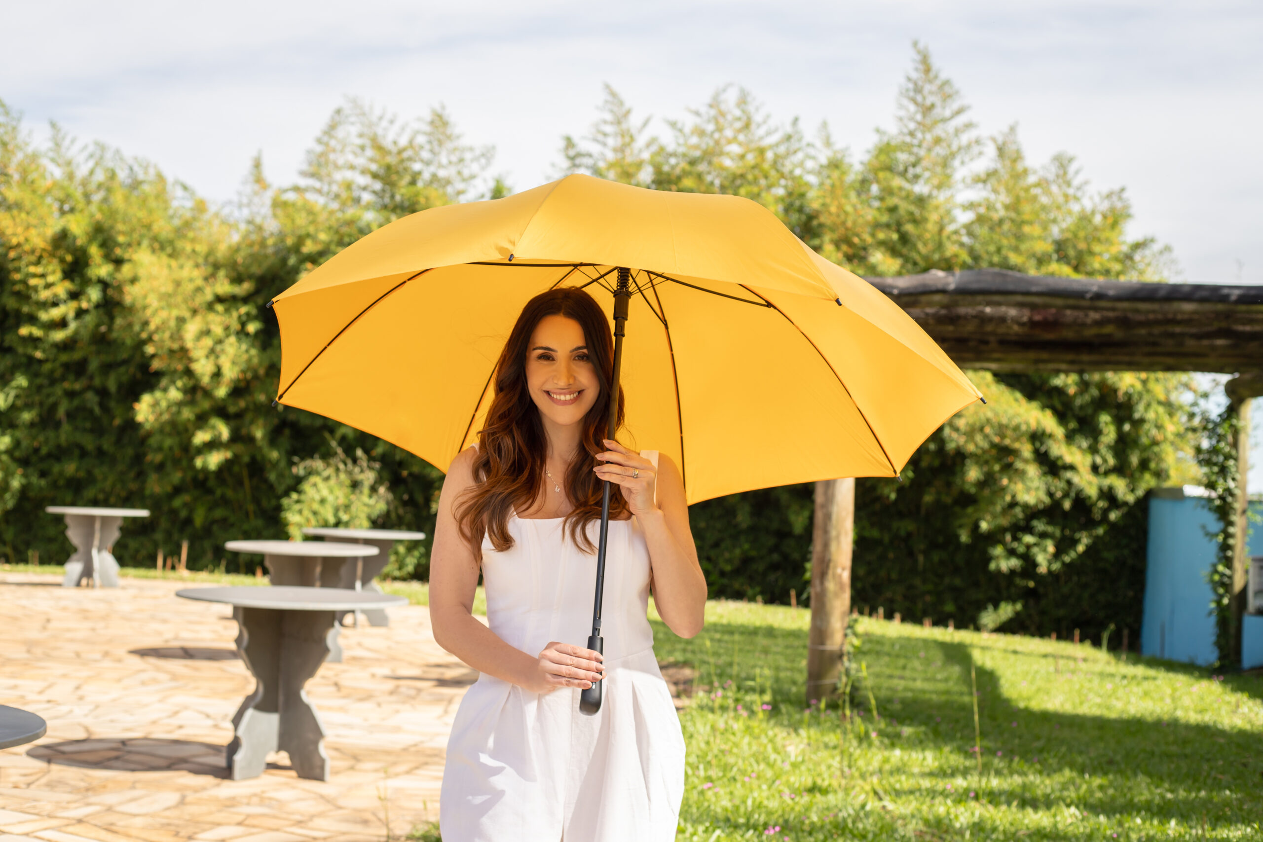 Guarda-chuva amarelo personalizado Florença em uso ao ar livre, mesma identidade visual aplicada ao guarda-sol de clubes e resorts